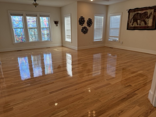 Gloss finish hardwood floor refinishing completed in a spacious Baltimore, MD living room.