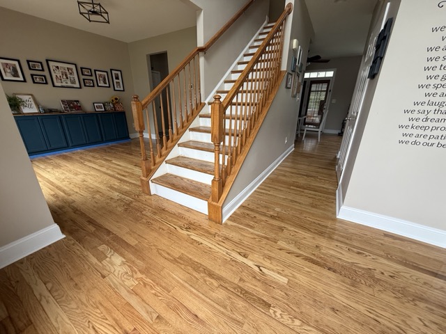 Hardwood floor refinishing around a home's entryway and staircase in Baltimore, MD.