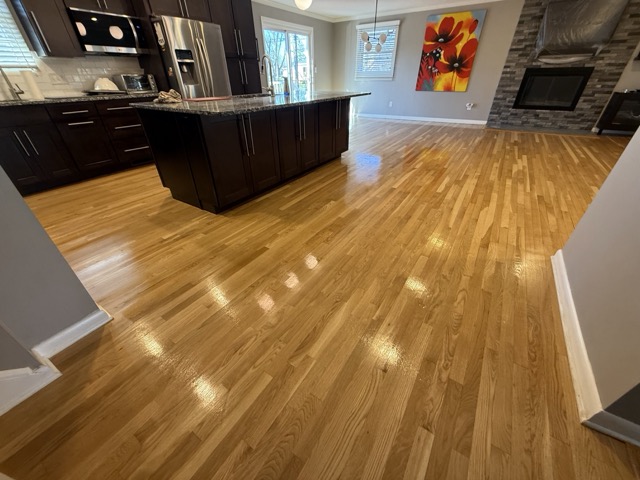 Hardwood floor refinishing throughout a kitchen and living area in Baltimore, MD by Flawless Floors.