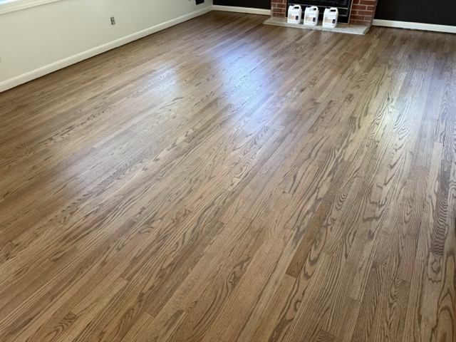 Refinished oak hardwood floors restored to like-new condition in a Baltimore, MD family room.